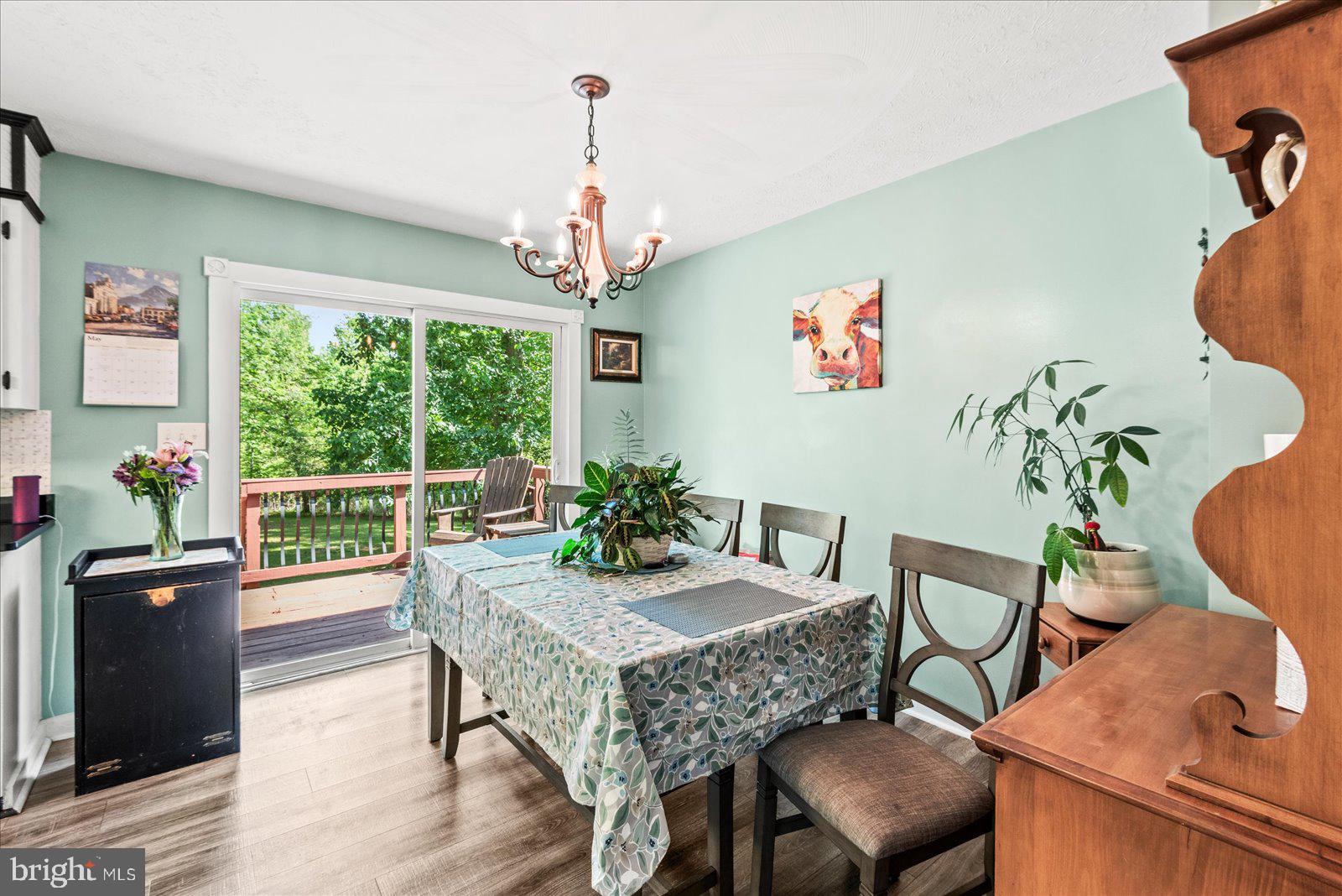 804 Buggy Lane Rochelle, VA 22738 - Photo 18 of 50 a dining room with wooden floor a chandelier a wooden table and chairs