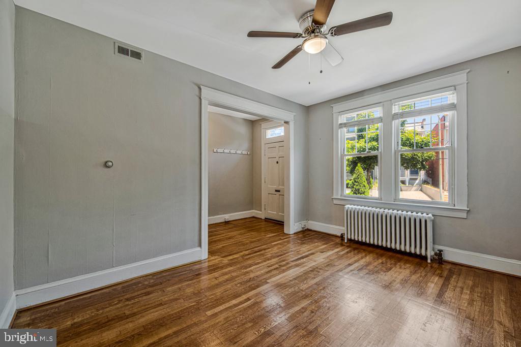 2406 37th Street Northwest Washington, DC 20007 - Photo 15 of 44 an empty room with wooden floor fan and windows