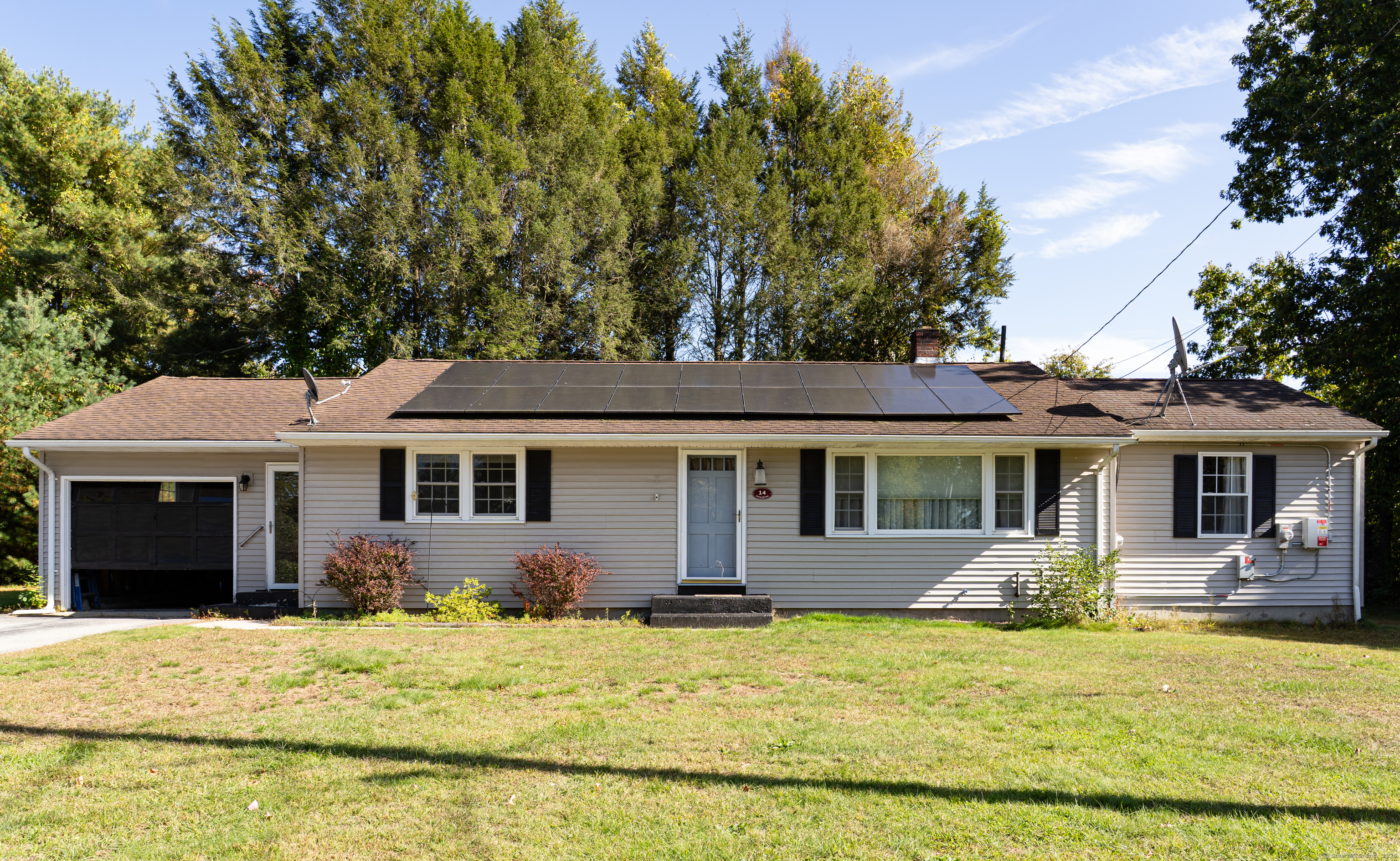 a front view of house with yard and trees around