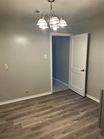 a view of a chandelier in big room and wooden floor