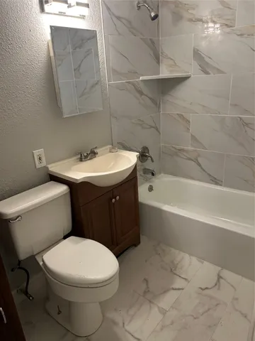 a bathroom with a sink a toilet and bathtub