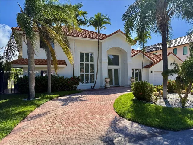 a view of a white house with a yard and potted plants