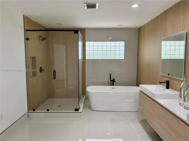 a bathroom with a tub a sink and mirror