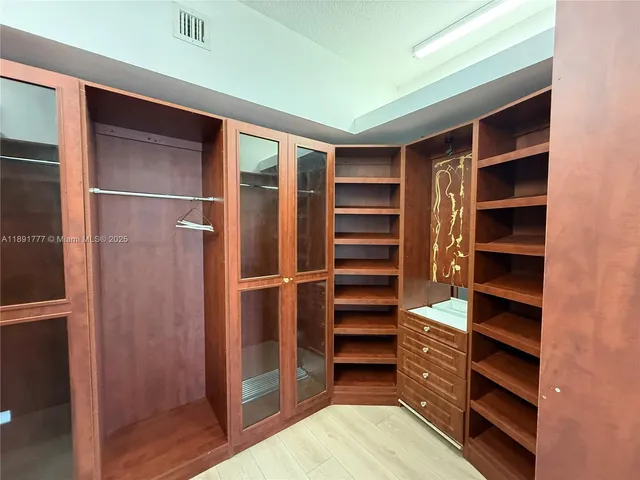 a view of walk in closet with empty racks