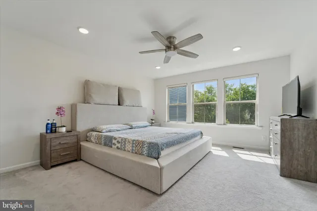 a spacious bedroom with a bed and a flat screen tv