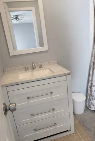 a bathroom with a granite countertop toilet and a sink