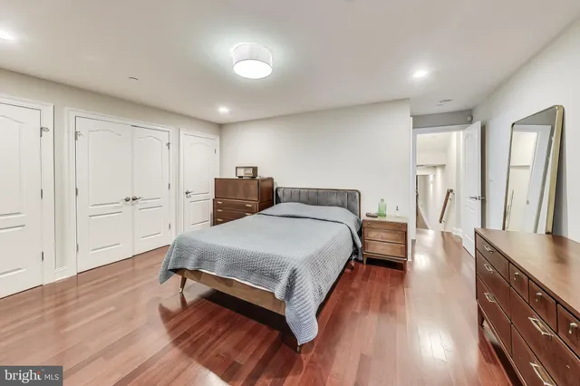 a spacious bedroom with a bed and wooden floor