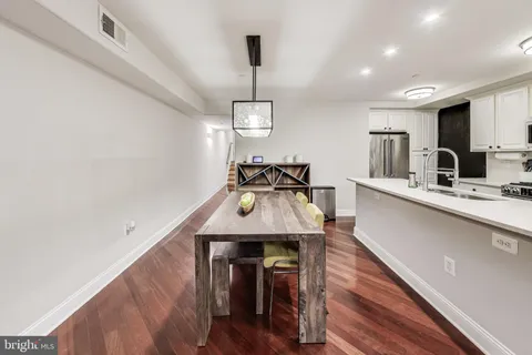 a kitchen with stainless steel appliances wooden floor dining table and chairs
