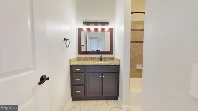 a bathroom with a granite countertop sink and a mirror