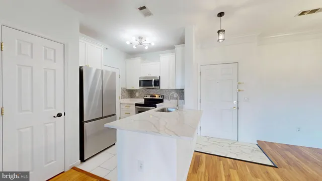 a kitchen with stainless steel appliances a refrigerator and microwave