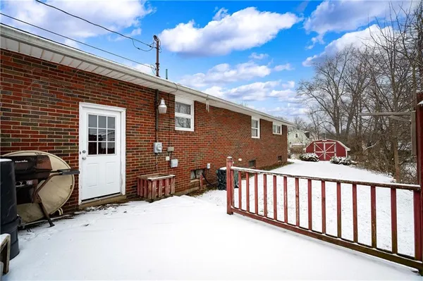 a front view of a house with a yard covered in snow