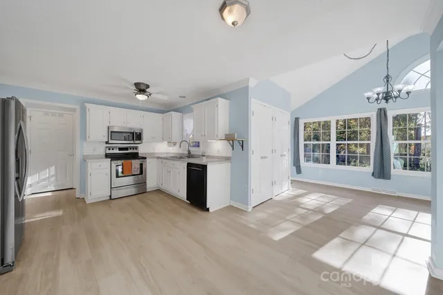 a kitchen with stainless steel appliances granite countertop a stove a sink and a refrigerator