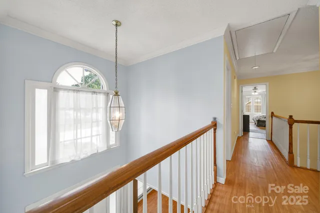 a view of a hallway with wooden floor and stairs