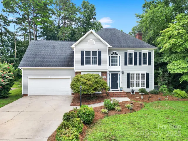 a front view of a house with a yard and potted plants