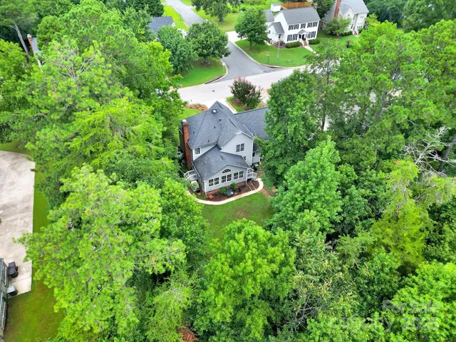 an aerial view of a house with a yard and lake view