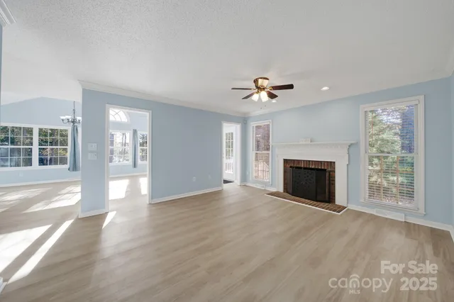 a view of an empty room with a fireplace and a window