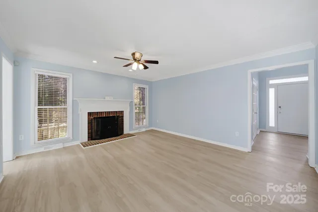 a view of an empty room with a fireplace and a window