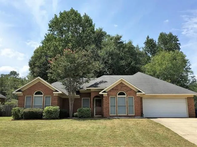 a front view of a house with a garden and plants