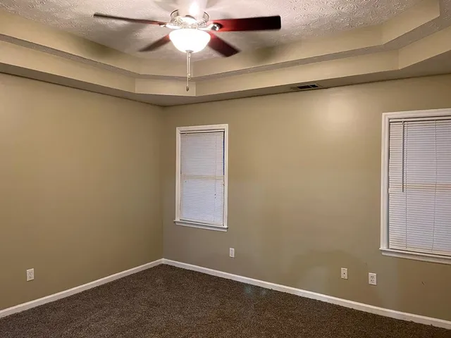 an empty room with windows and closet