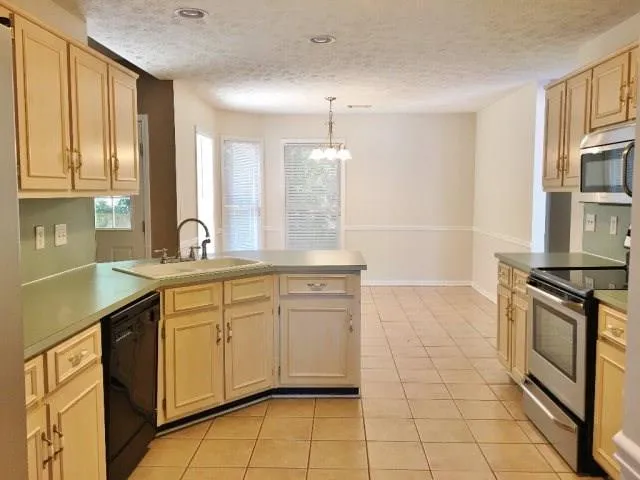 a kitchen with a sink a refrigerator and cabinets