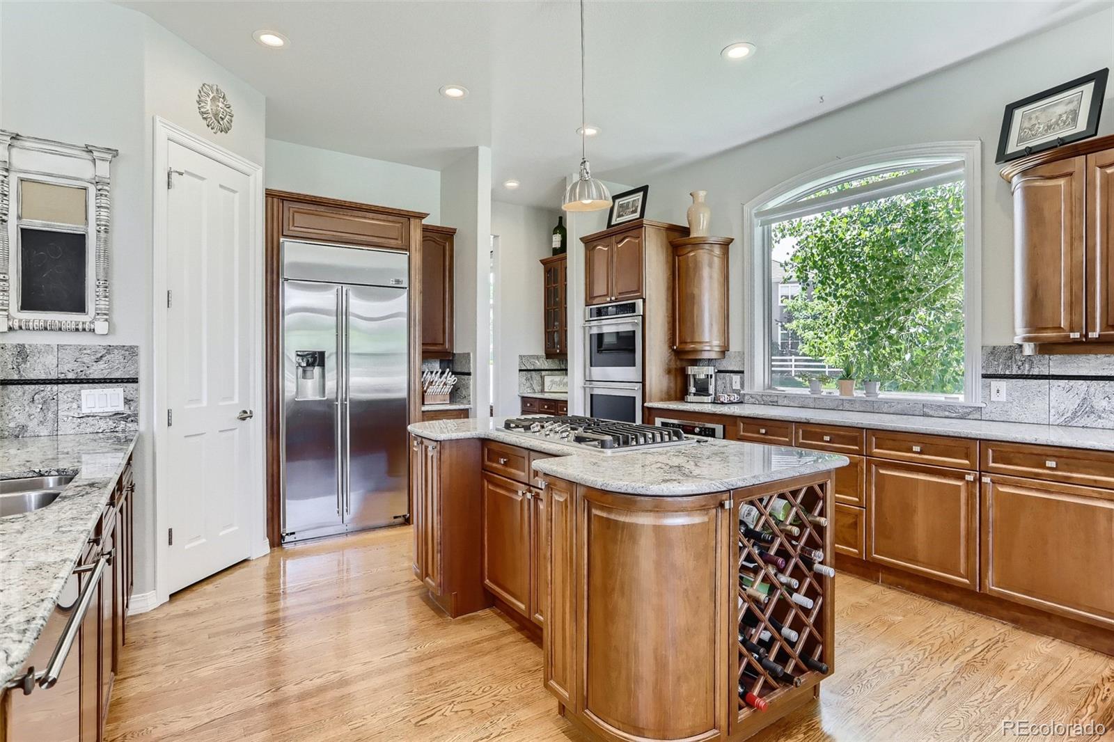 10189 Longview Drive Lone Tree, CO 80124 - Photo 12 of 40 a kitchen with stainless steel appliances granite countertop a sink a stove a refrigerator and island