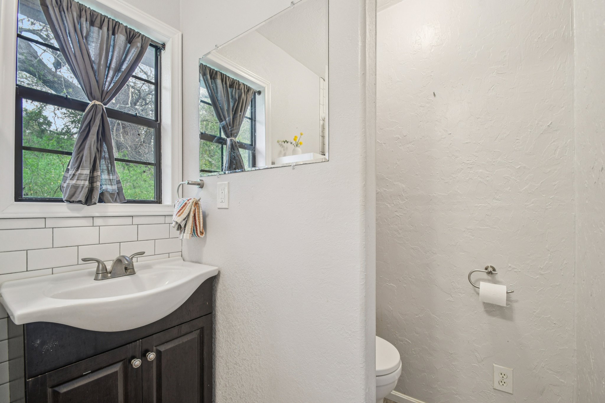2108 River Hills Road Austin, TX 78733 - Photo 26 of 35 a bathroom with a sink a toilet and a window