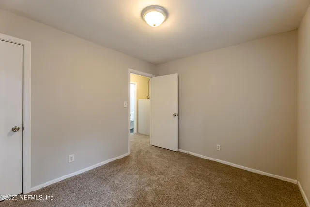 an empty room with closet and windows
