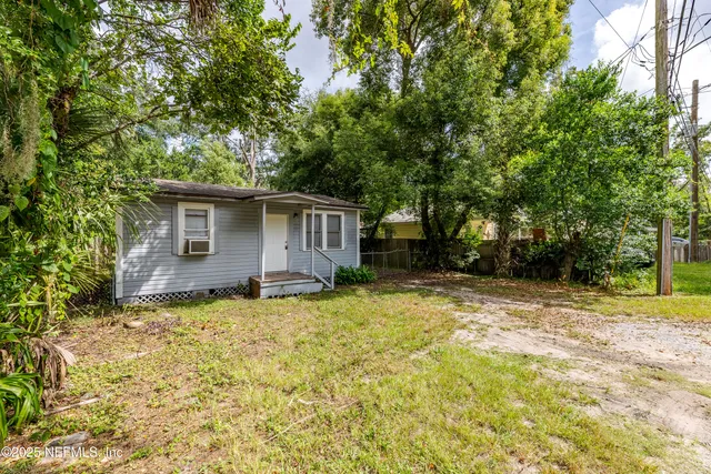 a view of a house with backyard and trees