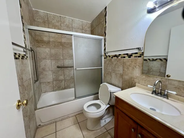 a bathroom with a granite countertop sink toilet a mirror and shower