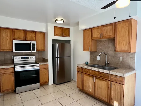a kitchen with stainless steel appliances granite countertop a refrigerator and a sink