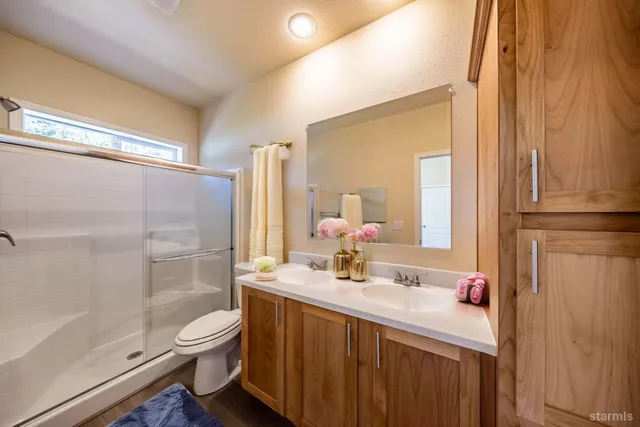 a bathroom with a sink a toilet and shower