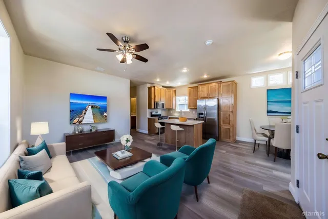 a living room with furniture kitchen view and a chandelier