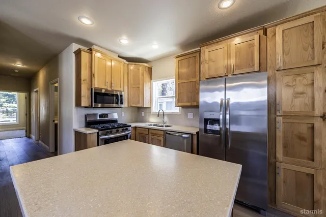 a kitchen with stainless steel appliances granite countertop a refrigerator stove microwave and sink