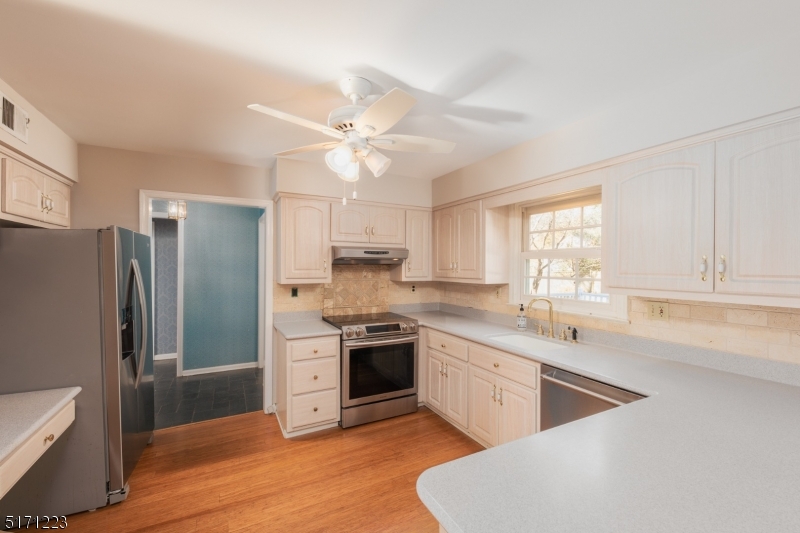 64 Old Coach Road Bernards, NJ 07920 - Photo 13 of 32 a kitchen with white cabinets and stainless steel appliances
