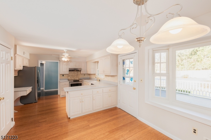 64 Old Coach Road Bernards, NJ 07920 - Photo 14 of 32 a kitchen with stainless steel appliances kitchen island granite countertop a refrigerator a sink a stove and white cabinets with wooden floor