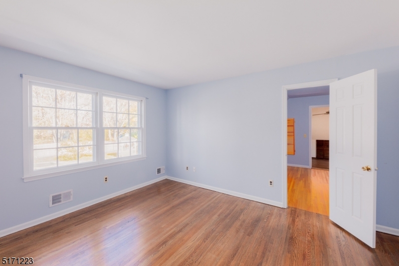64 Old Coach Road Bernards, NJ 07920 - Photo 22 of 32 an empty room with wooden floor and windows
