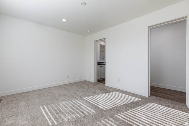749 Riddle Drive Fredonia, AZ 86022 - Photo 22 of 41 Unfurnished bedroom with light colored carpet, recessed lighting, and connected bathroom