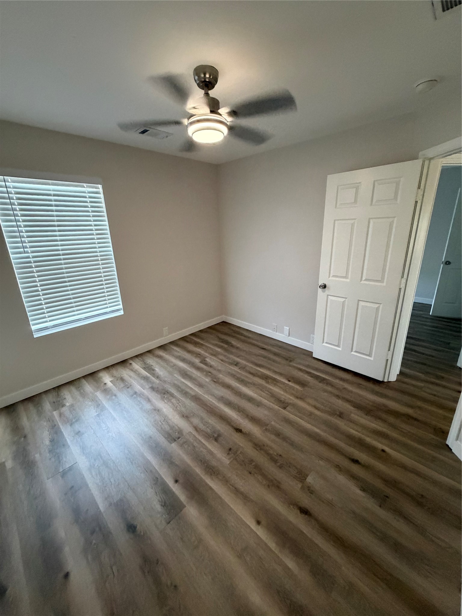 2123 Rustling Trees Way Spring, TX 77373 - Photo 17 of 21 This bright room features wood-style flooring, a ceiling fan with light, and a window with blinds, offering a cozy and modern feel.