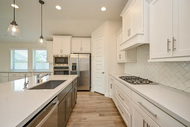 a kitchen with kitchen island a sink cabinets and wooden floor