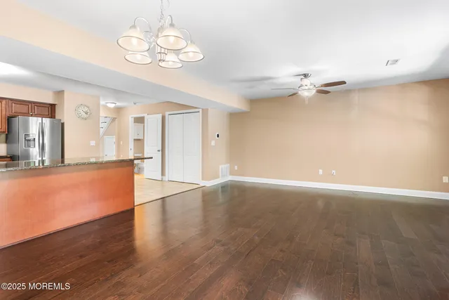 a view of an empty room with a chandelier fan