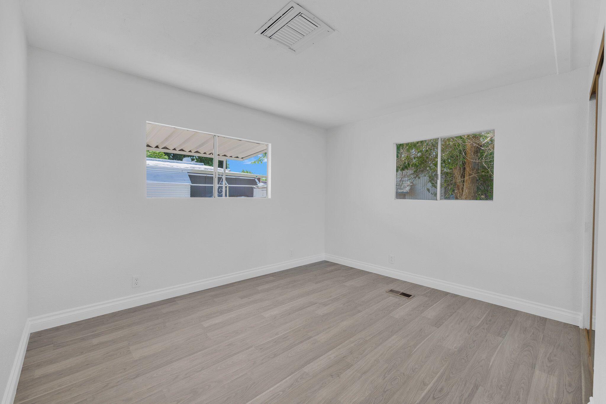 1301 East Avenue I Lancaster, CA 93535 - Photo 19 of 25 an empty room with wooden floor and windows