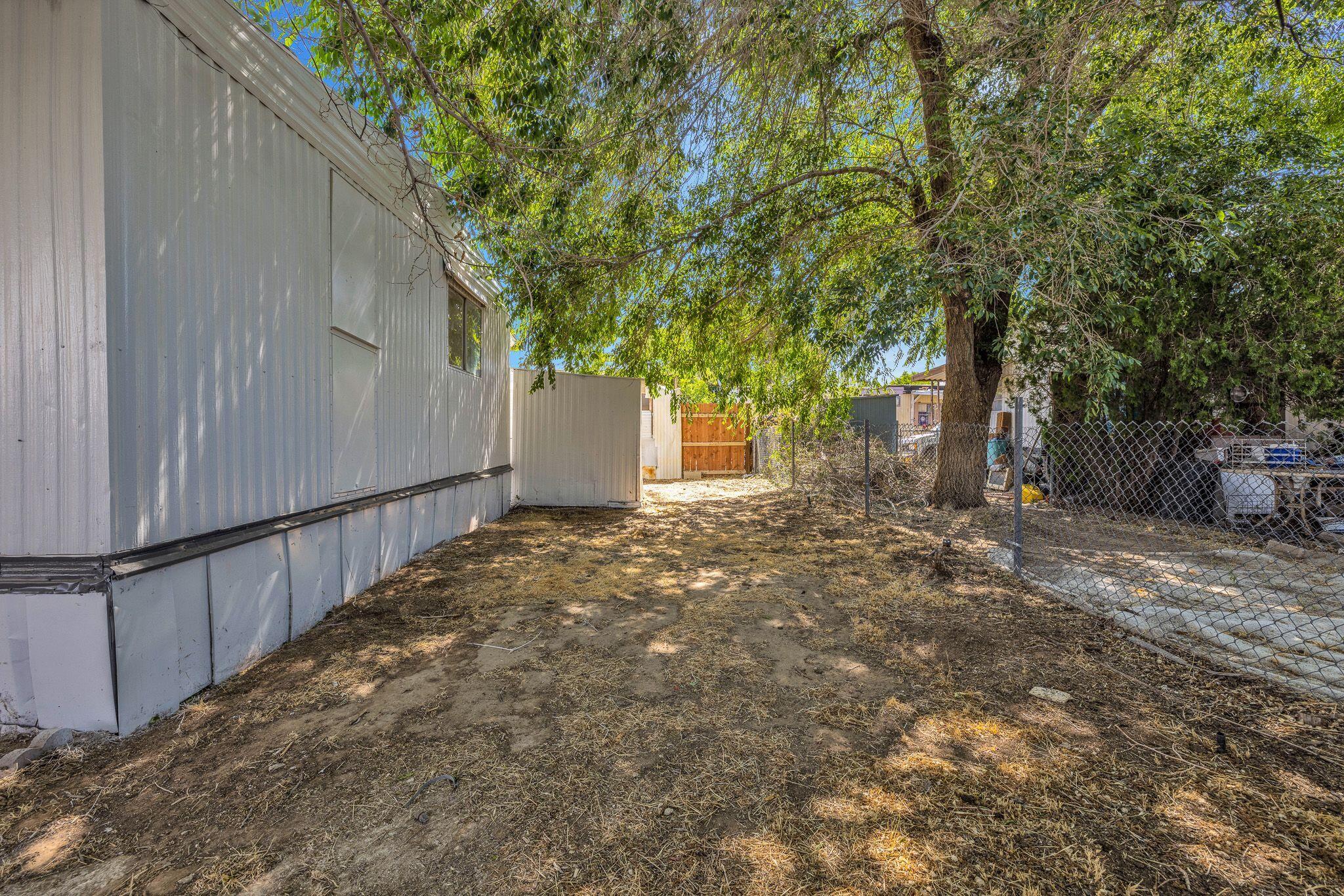 1301 East Avenue I Lancaster, CA 93535 - Photo 24 of 25 a view of a backyard with large trees and wooden fence