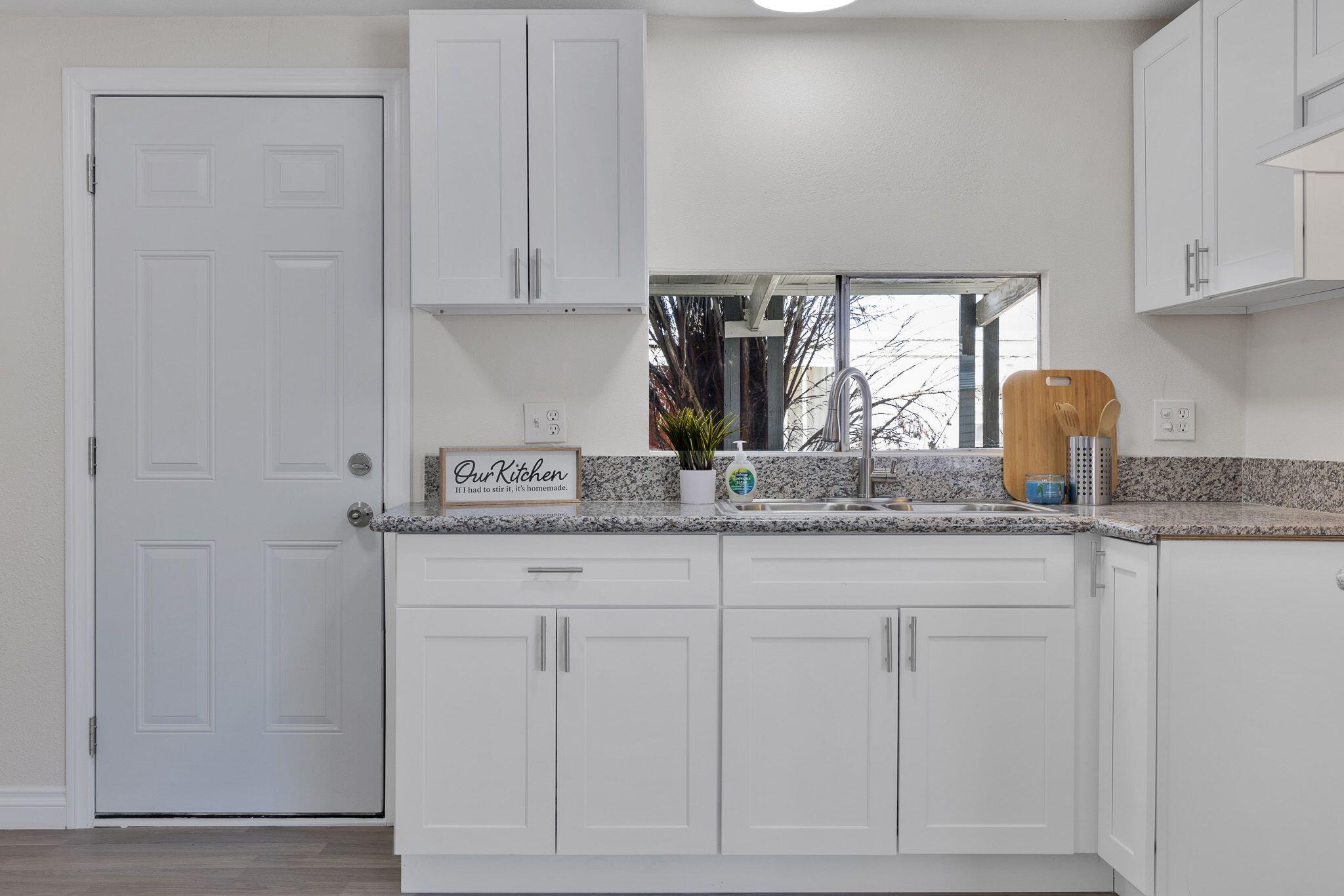 1301 East Avenue I Lancaster, CA 93535 - Photo 9 of 25 a kitchen with granite countertop white cabinets and a sink