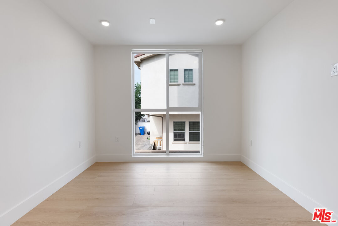 8561 Belmont Street, Unit 4 Cypress, CA 90630 - Photo 16 of 23 an empty room with wooden floor and windows