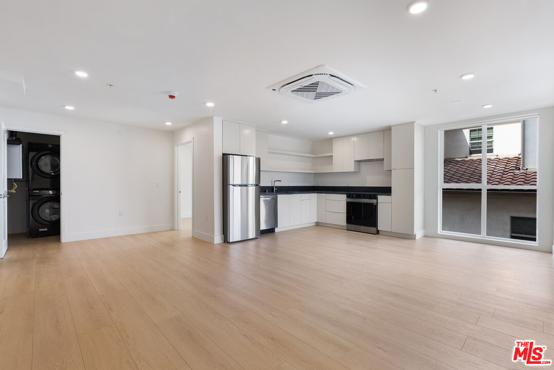 8561 Belmont Street, Unit 4 Cypress, CA 90630 - Photo 2 of 23 an empty room with wooden floor and kitchen