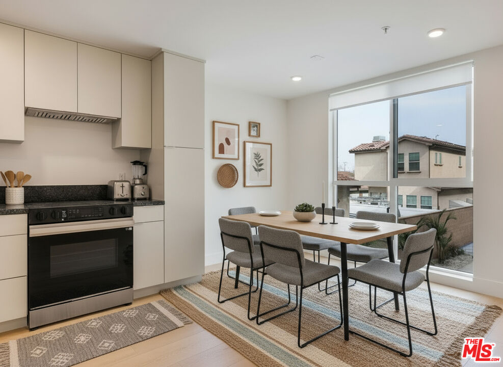 8561 Belmont Street, Unit 4 Cypress, CA 90630 - Photo 21 of 23 a view of a kitchen with a dining table and chairs