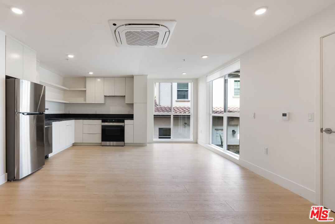 8561 Belmont Street, Unit 4 Cypress, CA 90630 - Photo 3 of 23 an empty room with wooden floor and windows