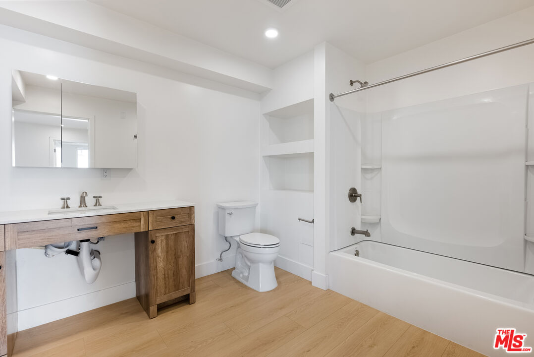 8561 Belmont Street, Unit 4 Cypress, CA 90630 - Photo 10 of 23 a bathroom with a granite countertop sink a toilet and shower