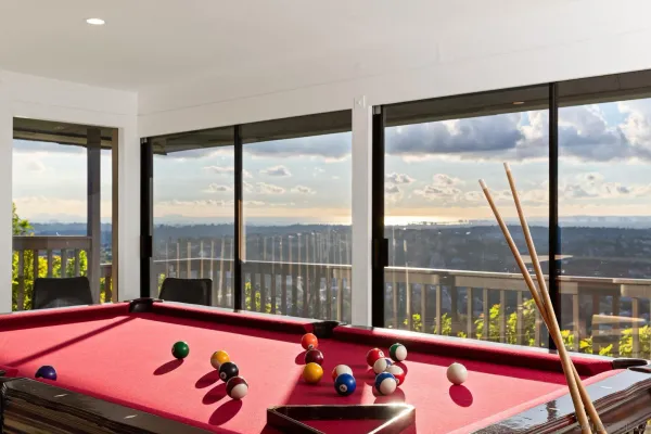 a room with pool table and windows