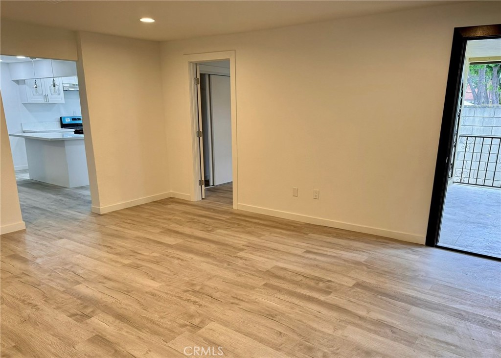 1362 South Downey Road Los Angeles, CA 90023 - Photo 6 of 30 a view of an empty room with wooden floor and a kitchen